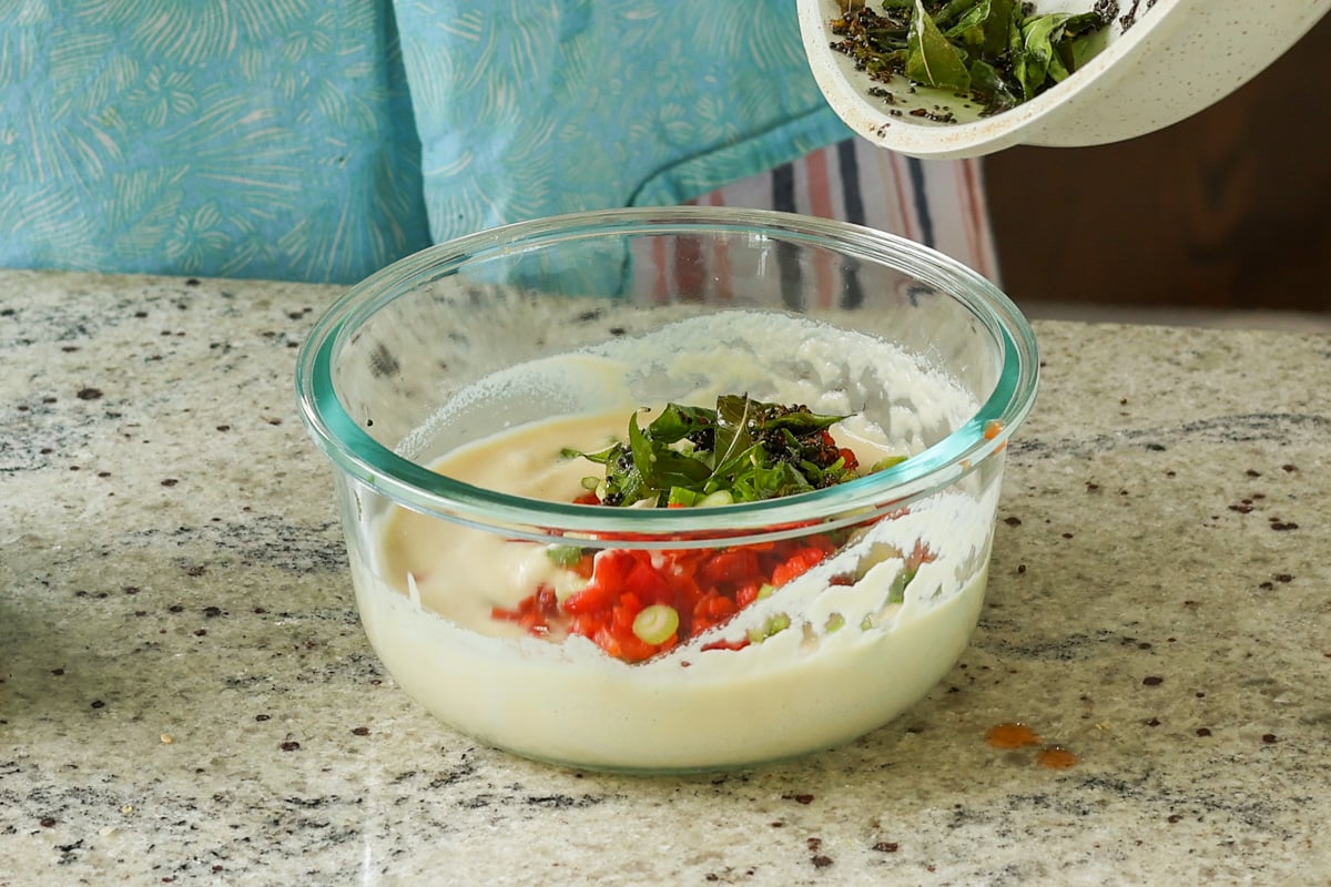 adding the spiced oil and veggies to the batter