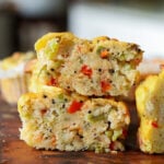 close-up of moong egg muffins on the cutting board with one cut in half, so you can see the inside