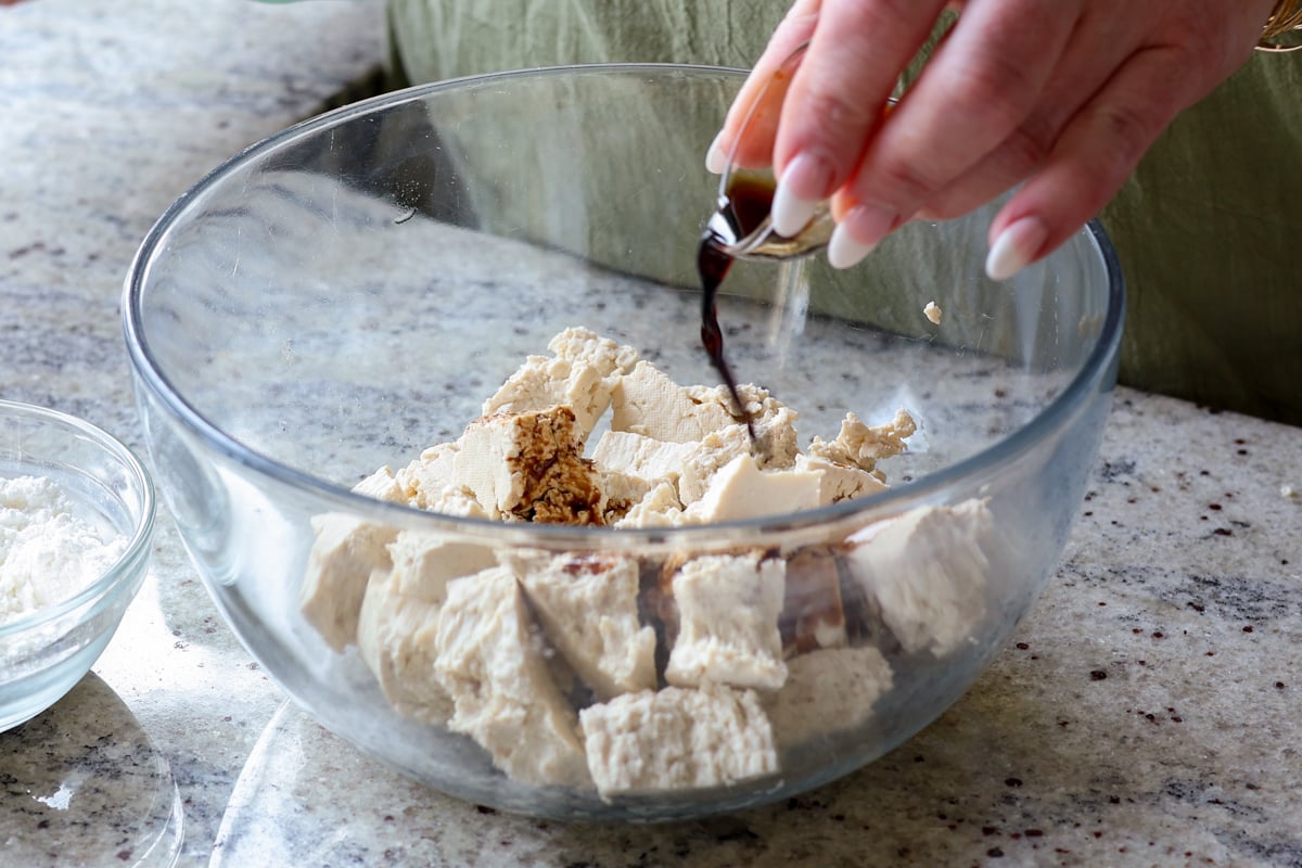 adding soy sauce to the torn tofu