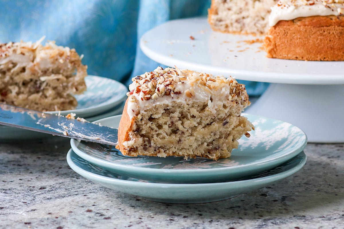 placing the slice of Italian cream cake on a plate