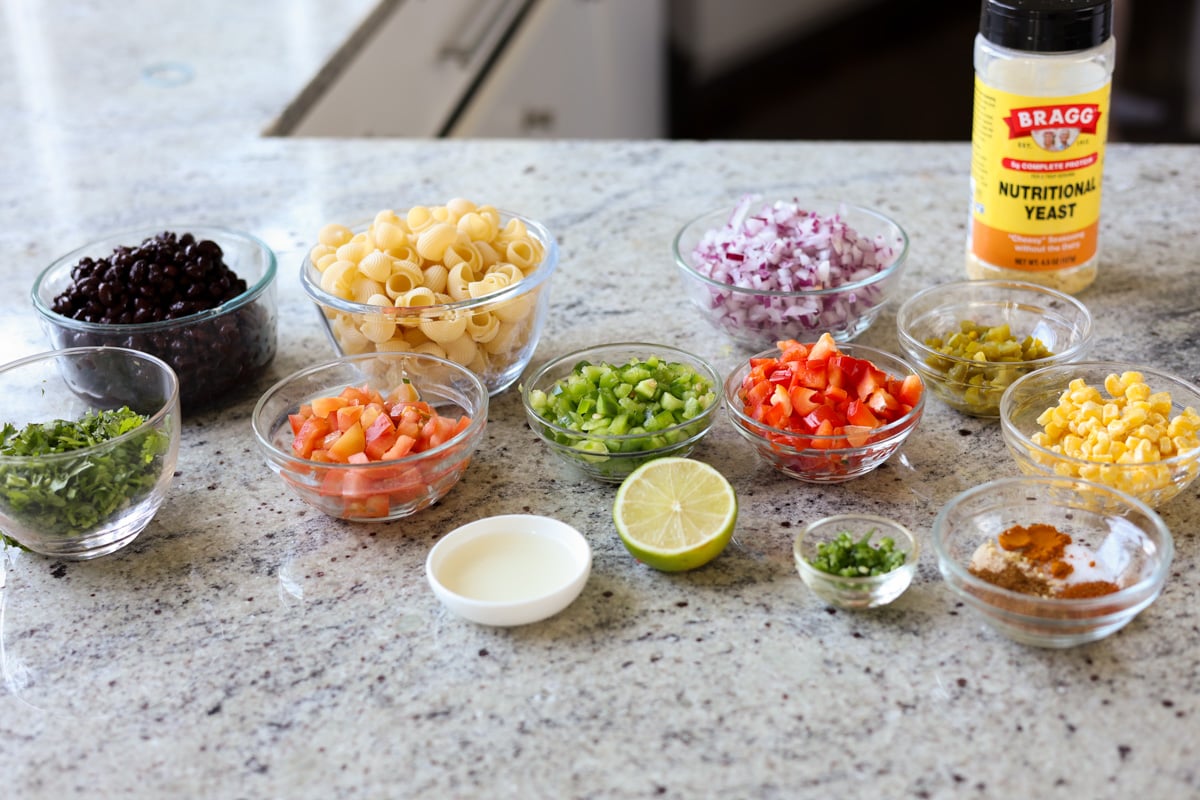 Ingredients for making southwestern salad in glass bowls on a granite countertop.