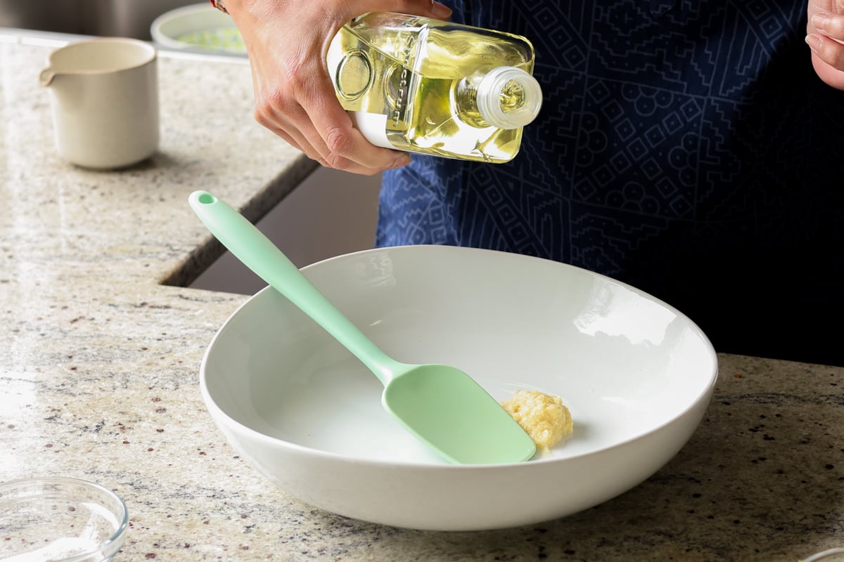 adding ginger garlic paste and oil to a mixing bowl
