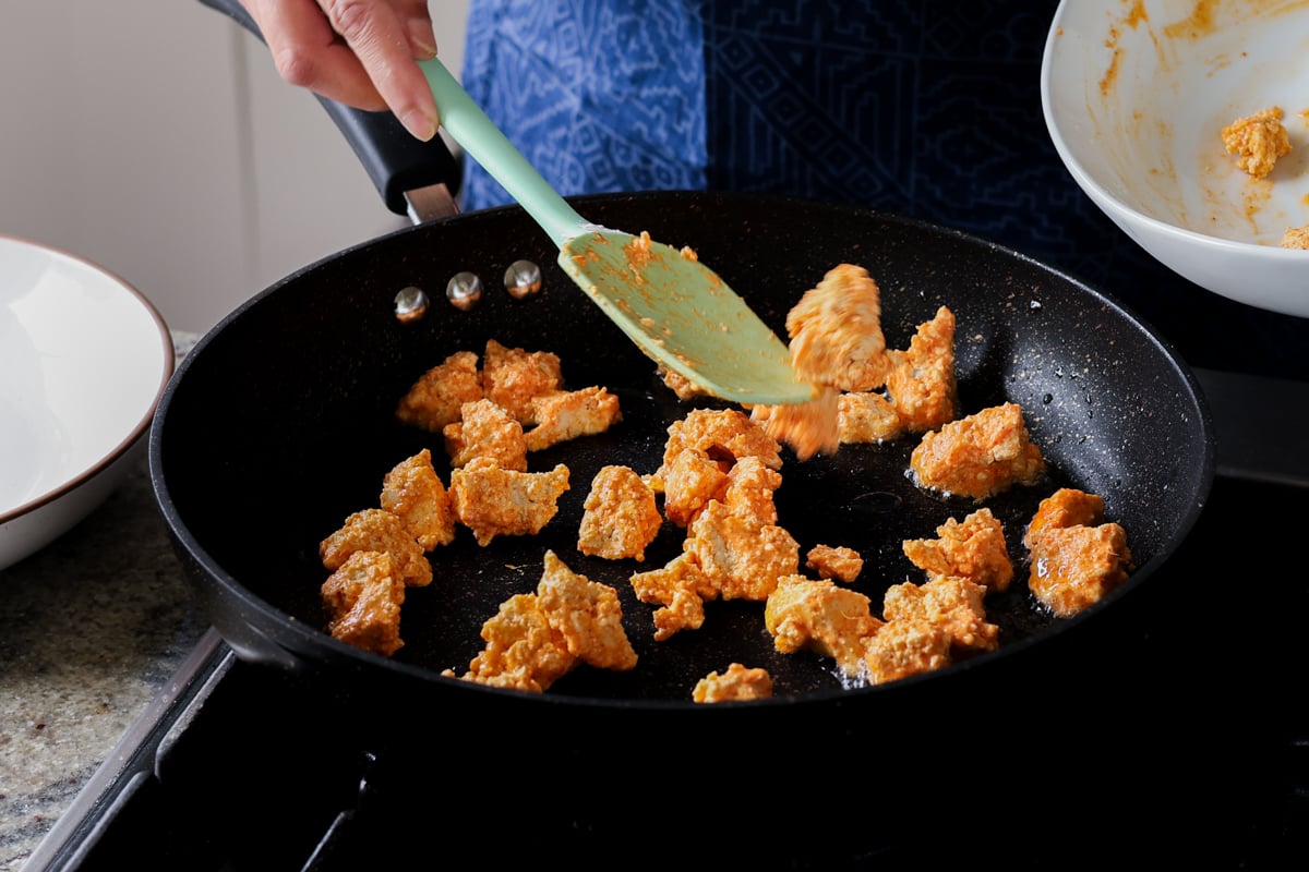 adding coated tofu to the pan