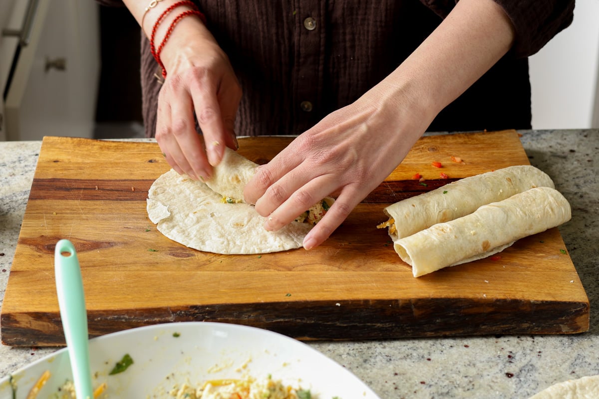 rolling the breakfast taquitos