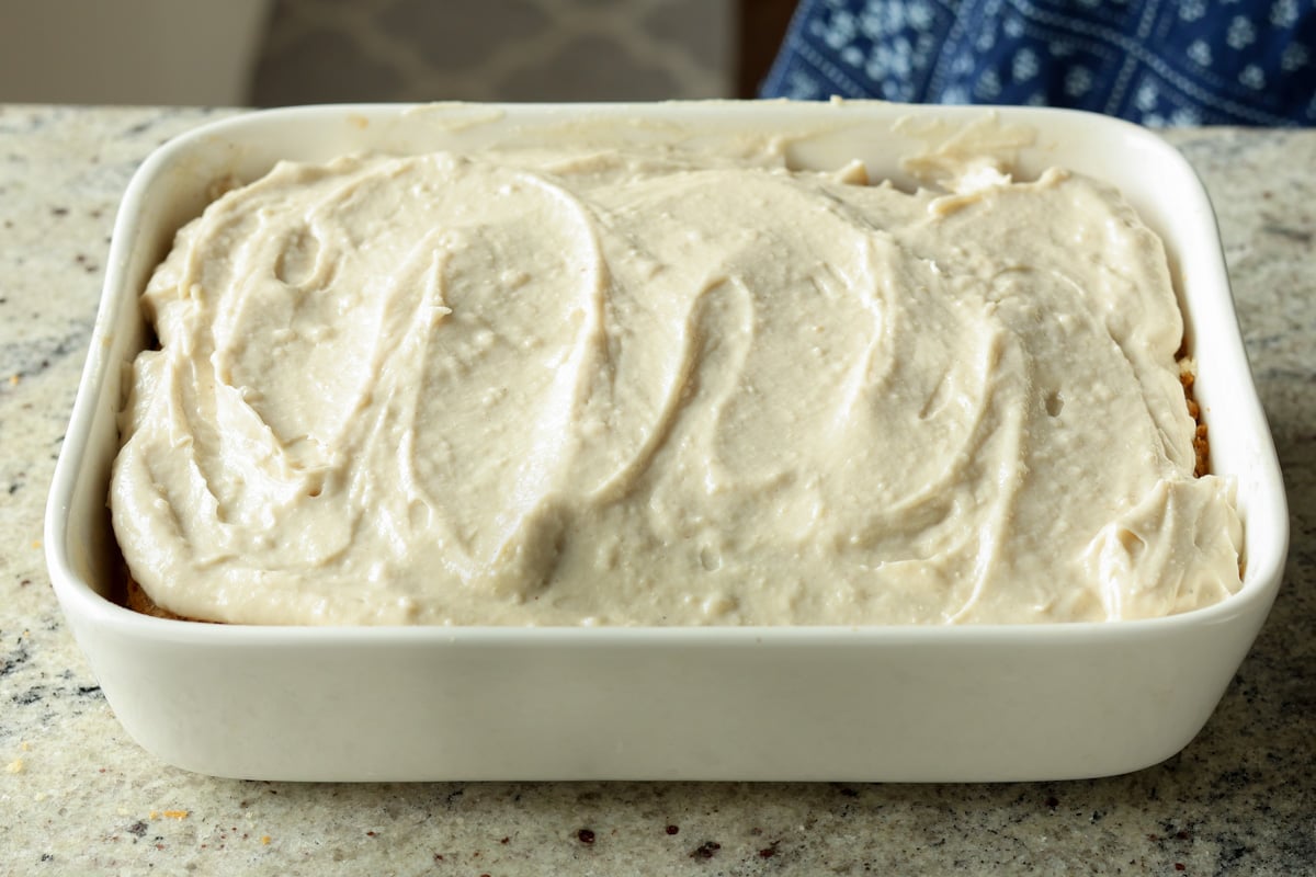 spreading cardamom cream onto second cake layer