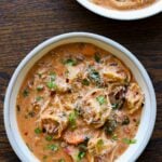 bowls of creamy tortellini soup on a wooden table