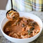 spoon taking a bite of tortellini soup