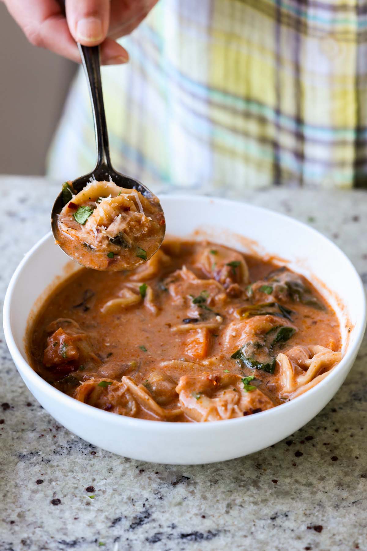 spoon taking a bite of tortellini soup