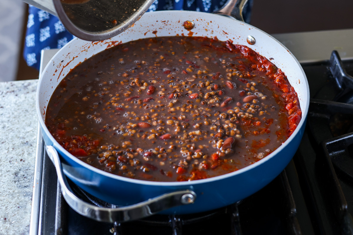 adding beans to the pan