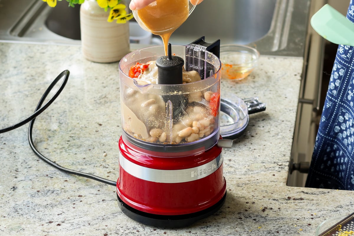 adding bean puree ingredients to the food processor