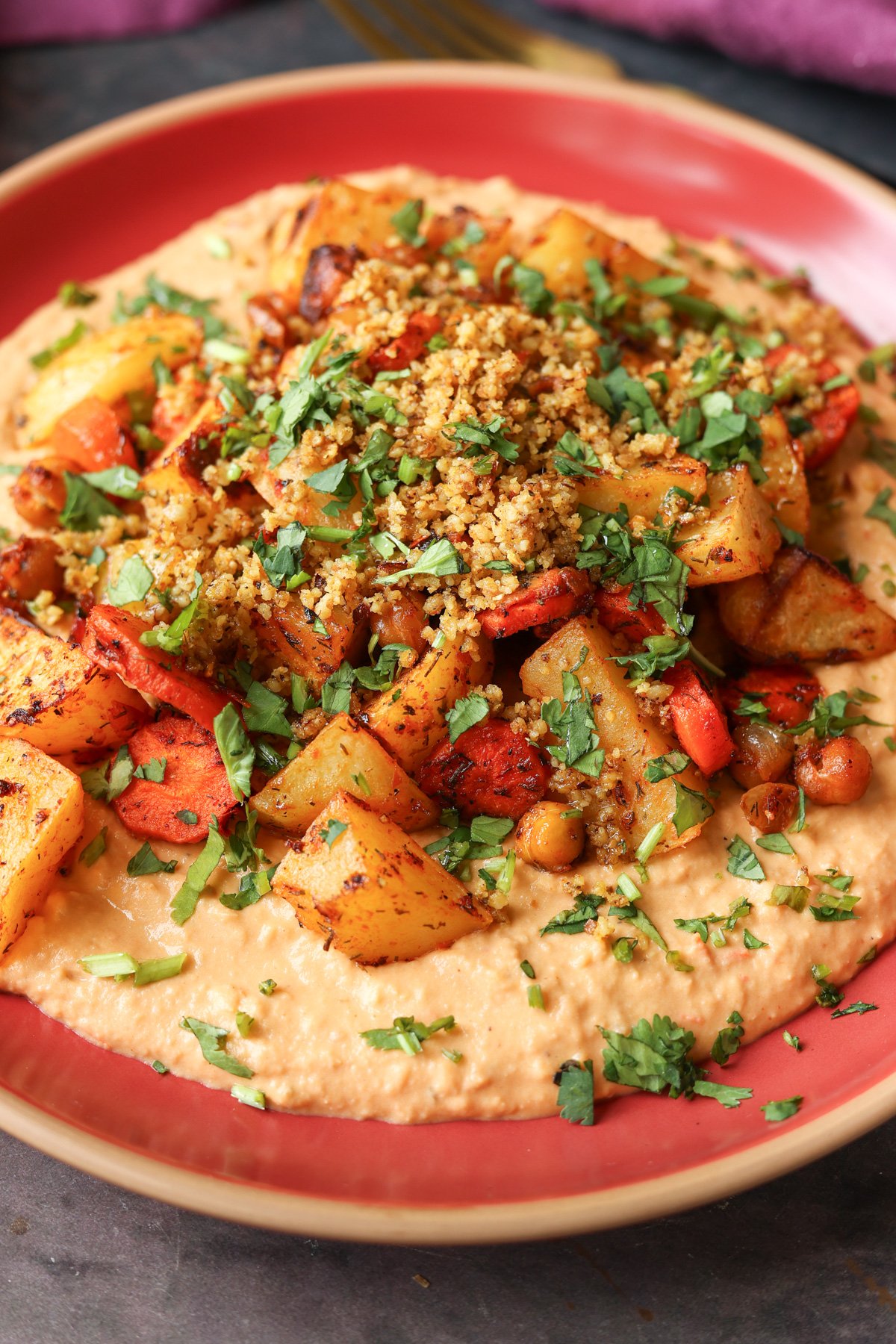 close-up of harissa bean puree topped with roasted vegetables and baharat walnuts