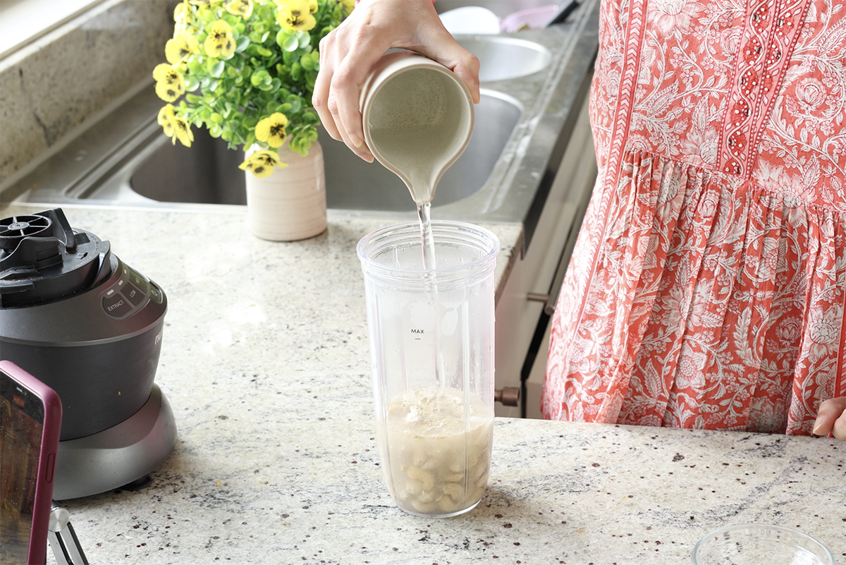 adding cashew cream ingredients to the blender