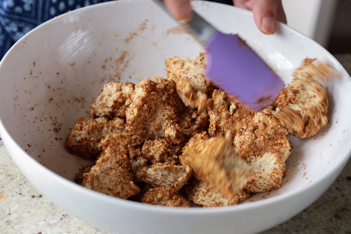 tossing the tofu in the spice rub
