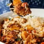 fork taking a bite of braised tofu and veggies with rice and herb sauce