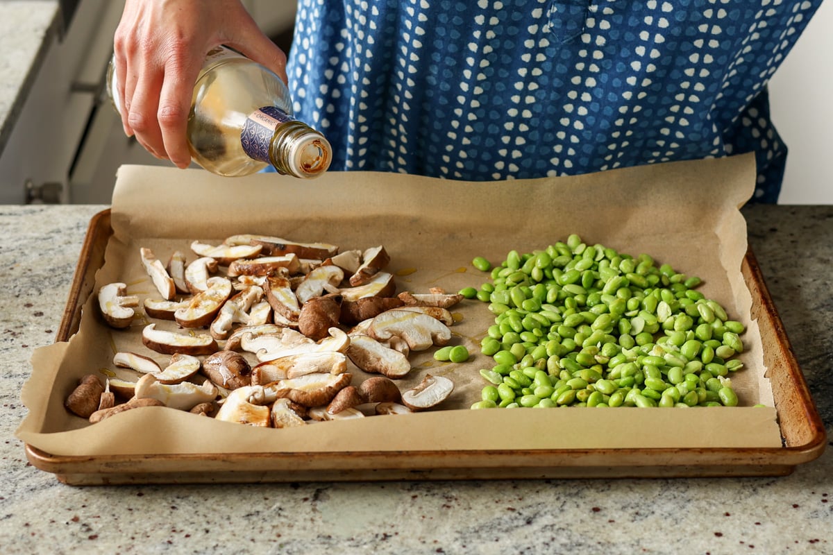 spreading out edamame and mushrooms on a baking sheet