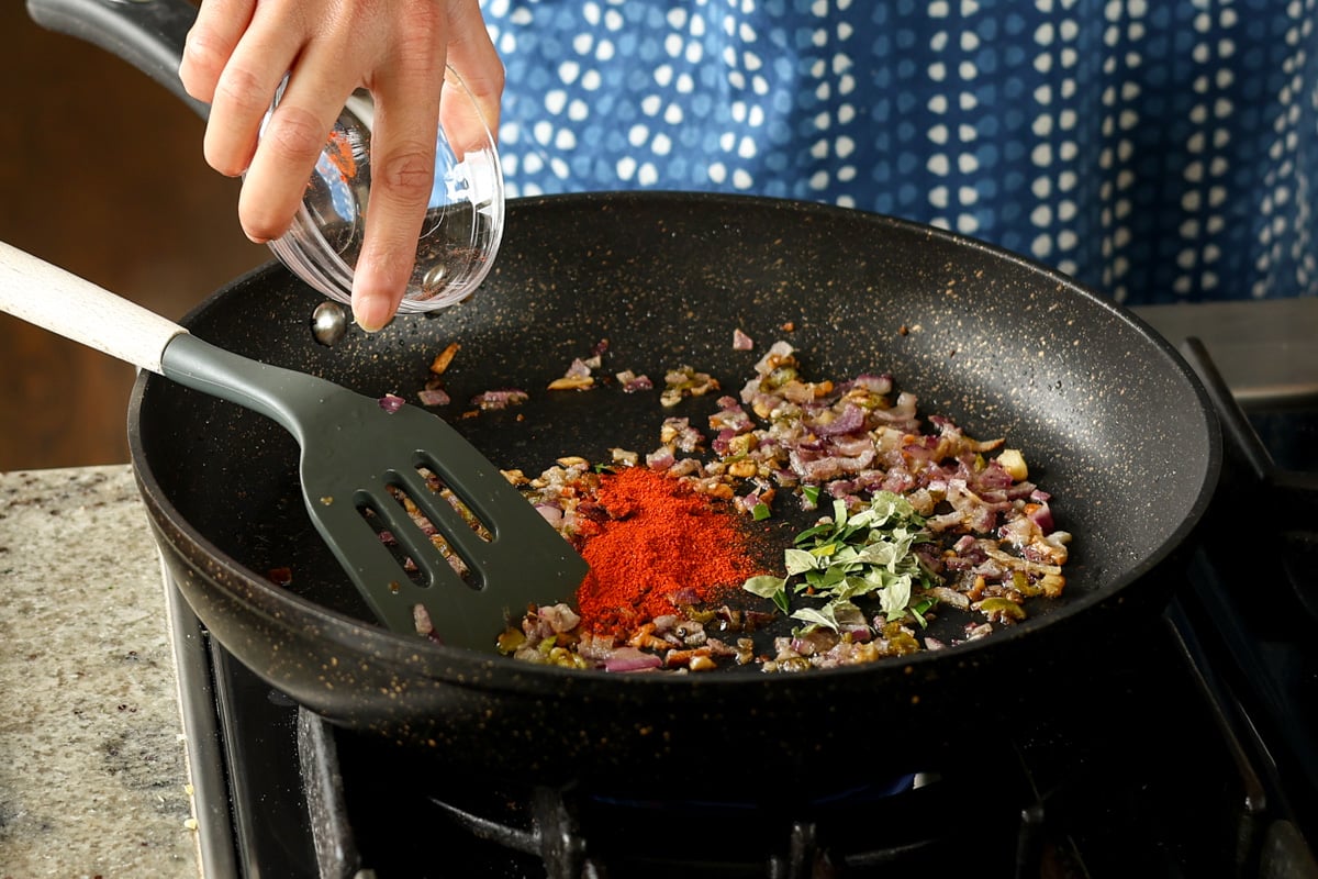adding Kashmiri chili powder to the pan