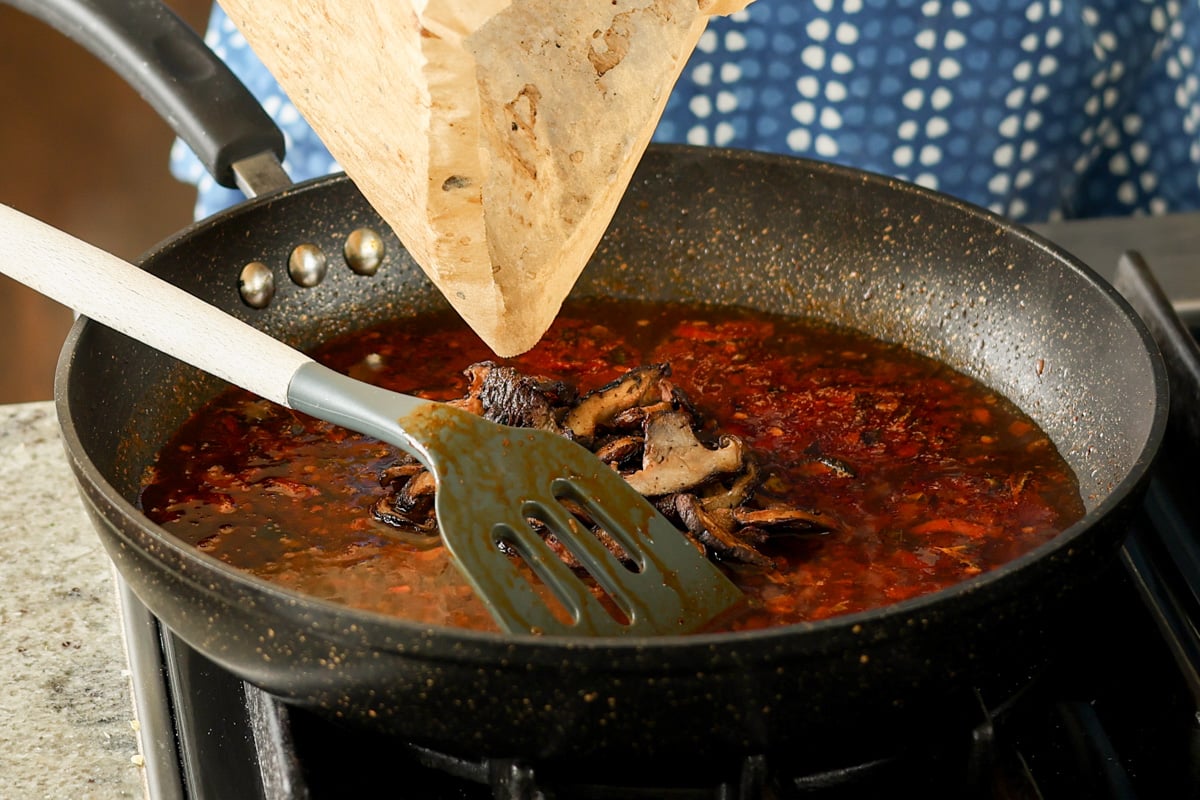 adding mushrooms to the sauce