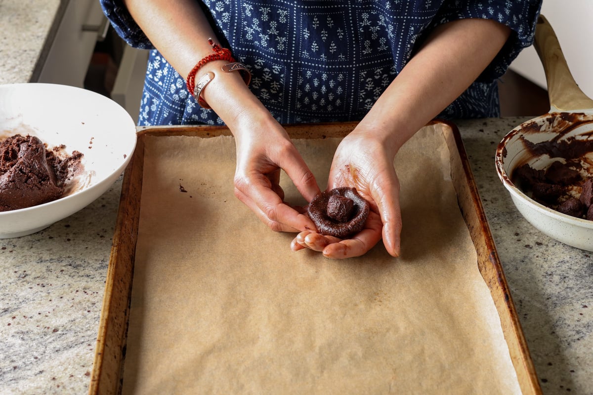 placing a ball of ganache into the center of a chocolate cookie