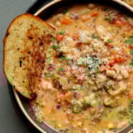lemon white bean soup in a bowl with garlic bread