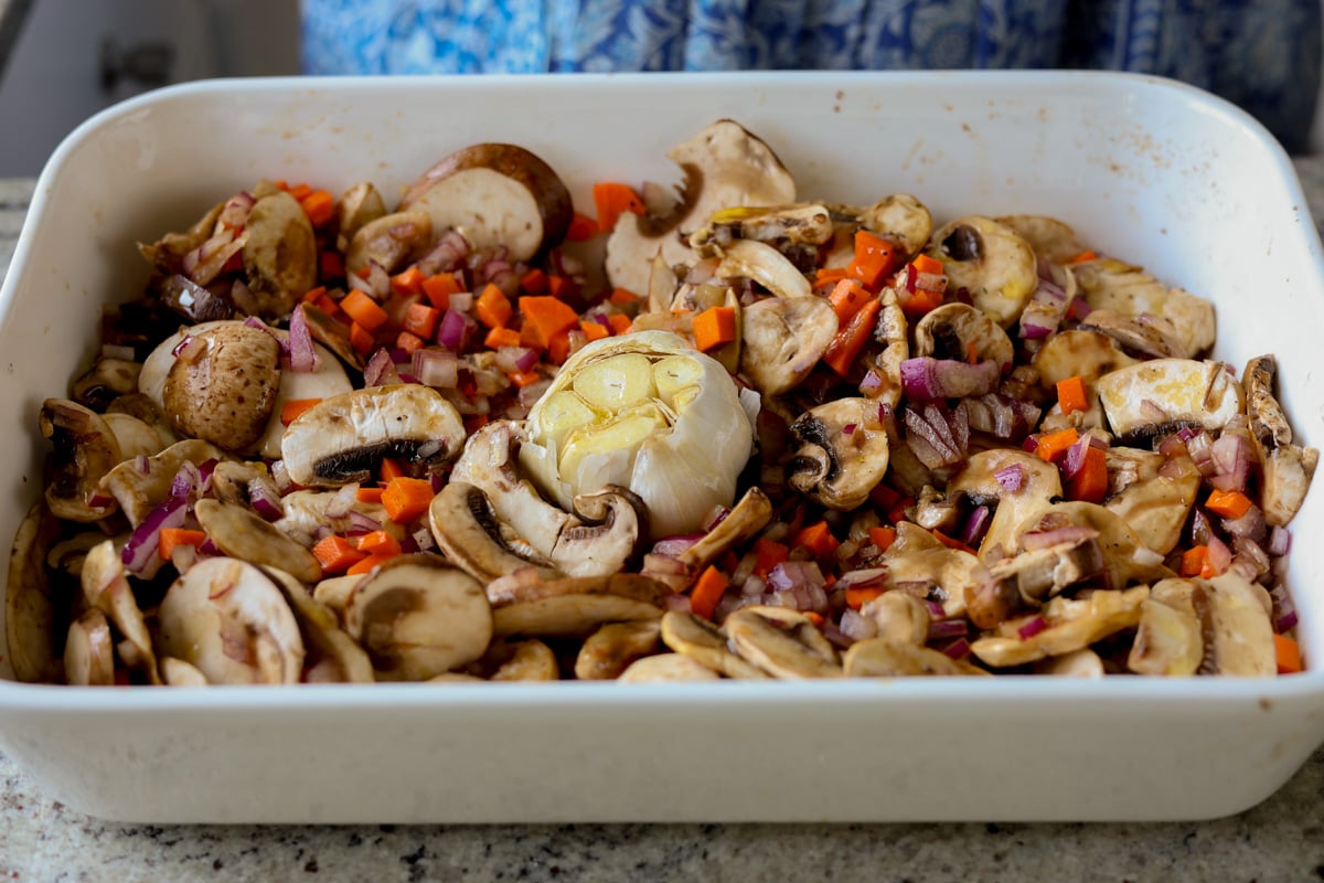 adding garlic head to the baking pan