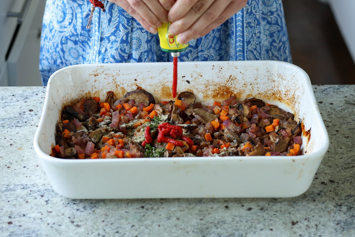 adding tomato paste to the baking pan