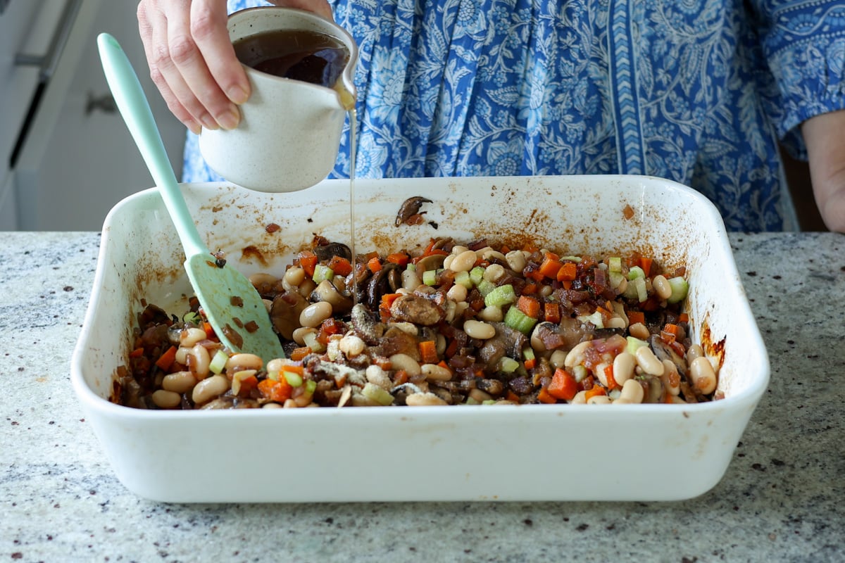 adding stock to the baking pan