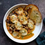 mushroom potato casserole in a bowl with garlic bread