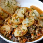 close-up of mushroom potato casserole in a bowl with garlic bread