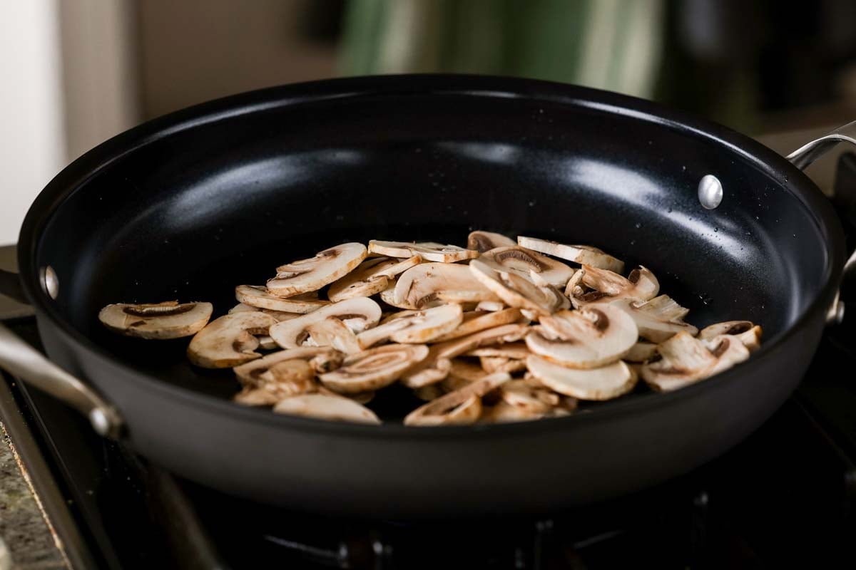 adding mushrooms to the pan