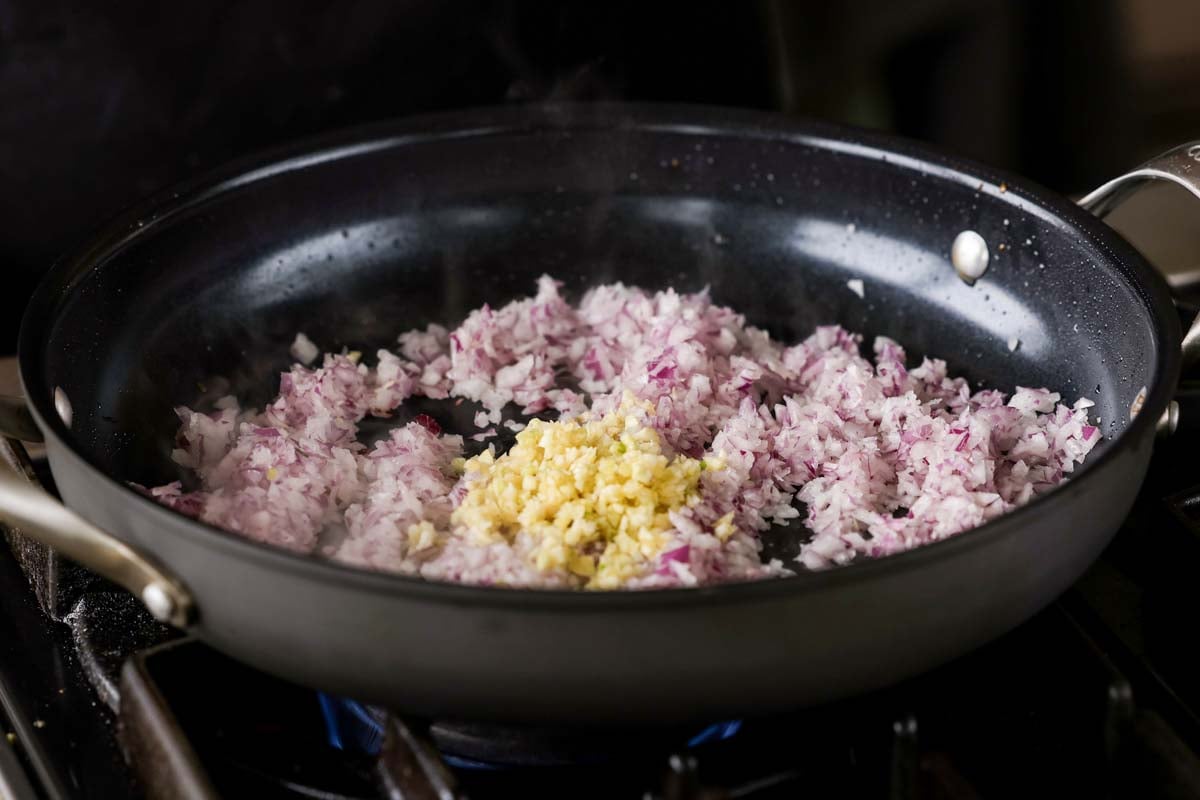 adding onion and garlic to the pan