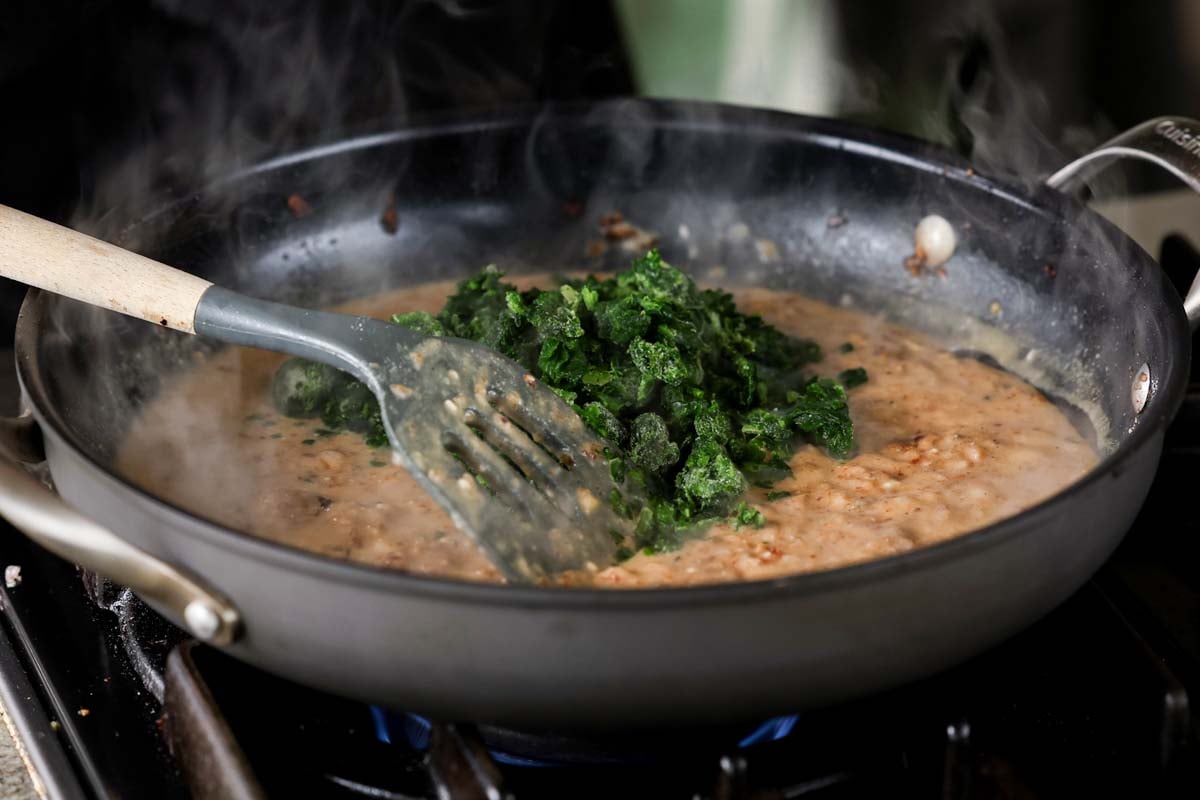 adding spinach to the pan