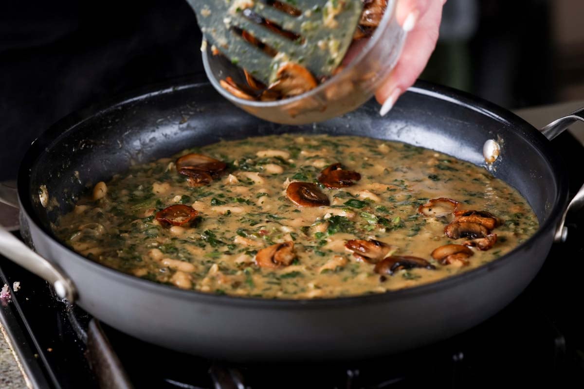 adding reserved mushrooms to the spinach mushroom beans