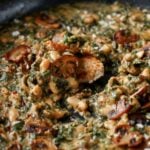 close-up of dipping bread into the spinach mushroom beans