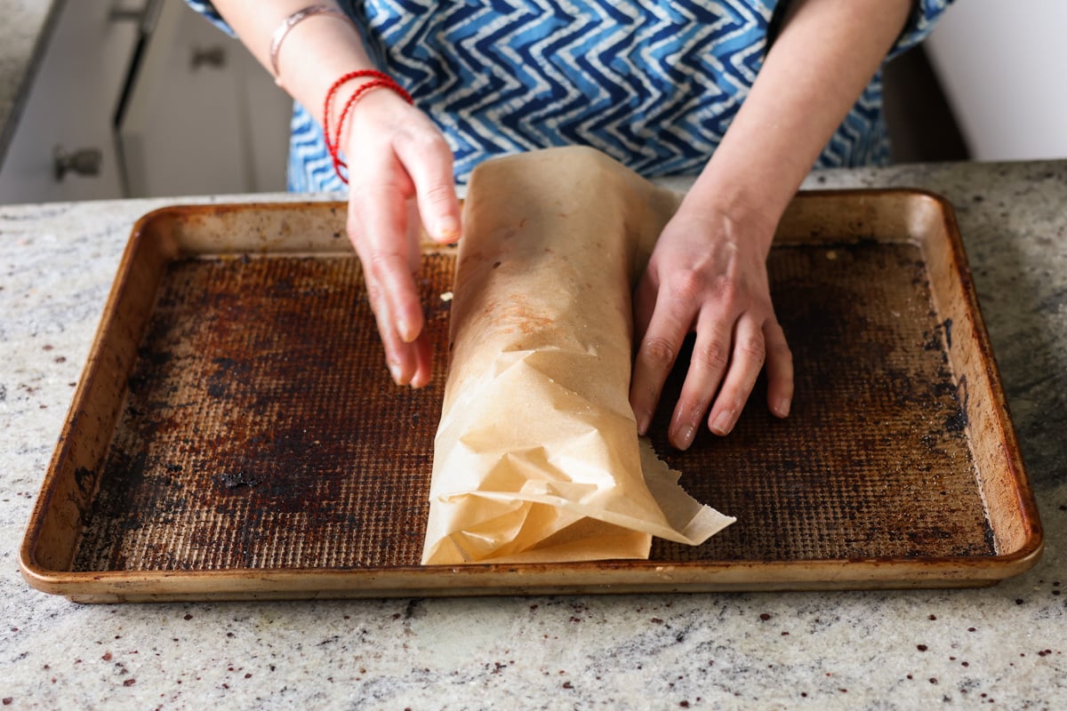 wrapping the sun dried tomato roast in parchment to bake