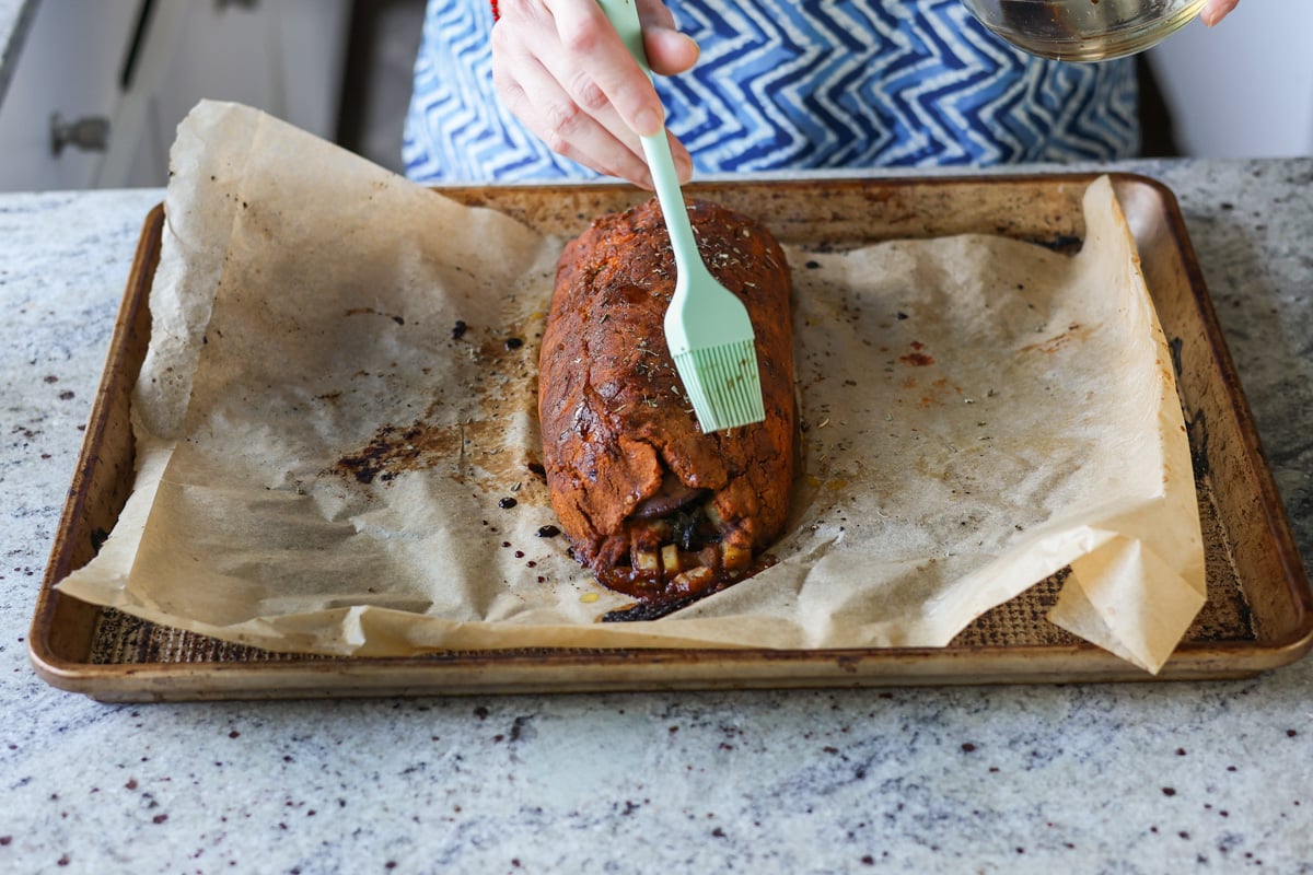 brushing glaze onto the sun dried tomato roast