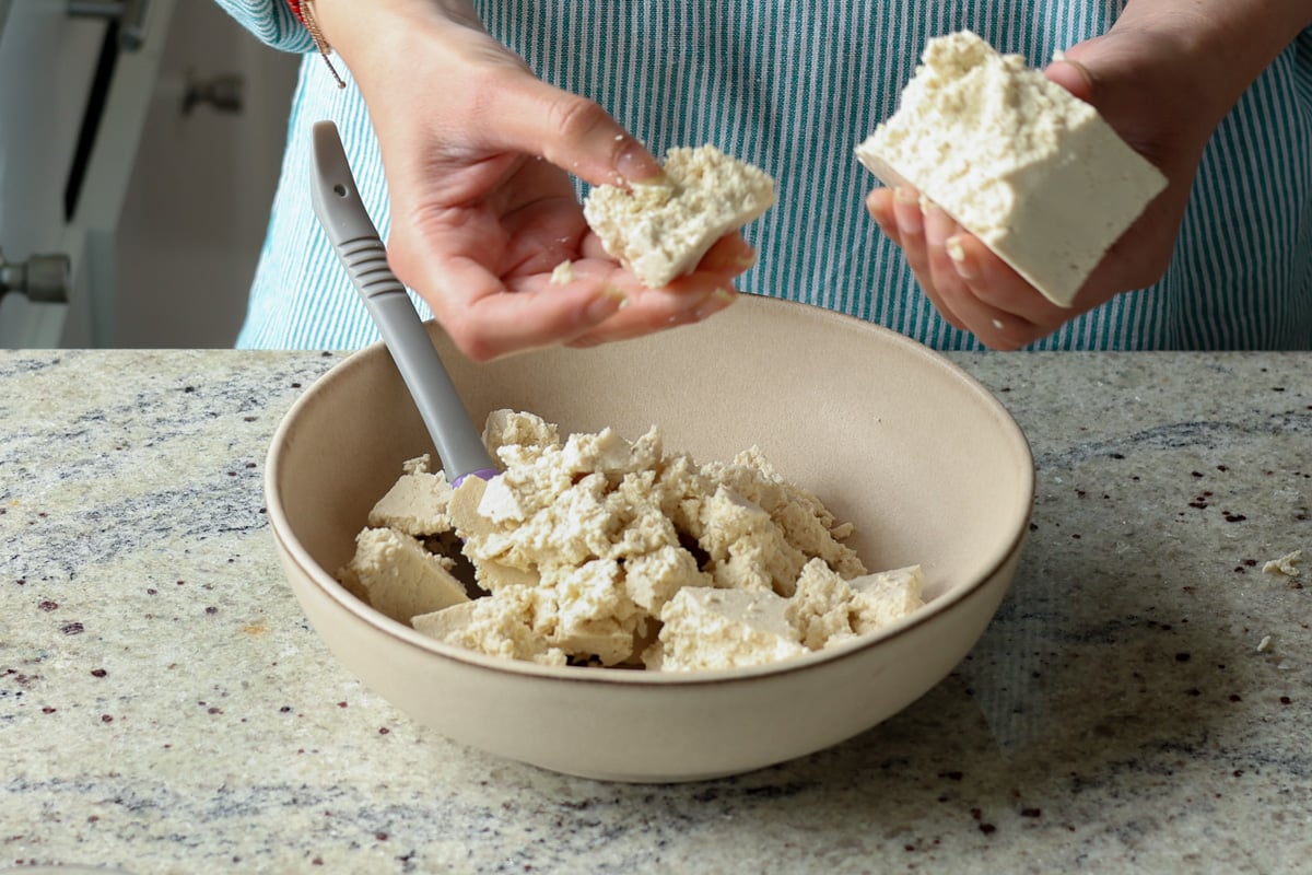 breaking the tofu into pieces