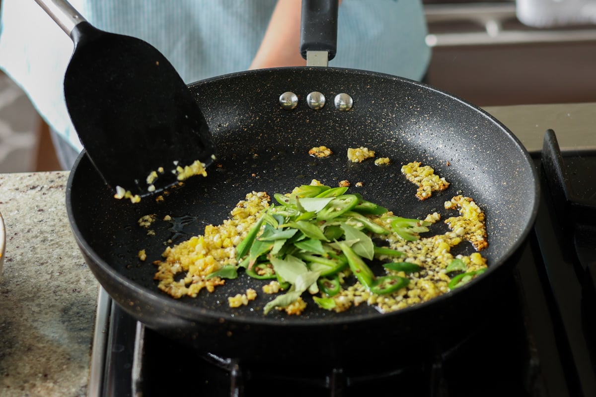 adding curry leaves to the pan