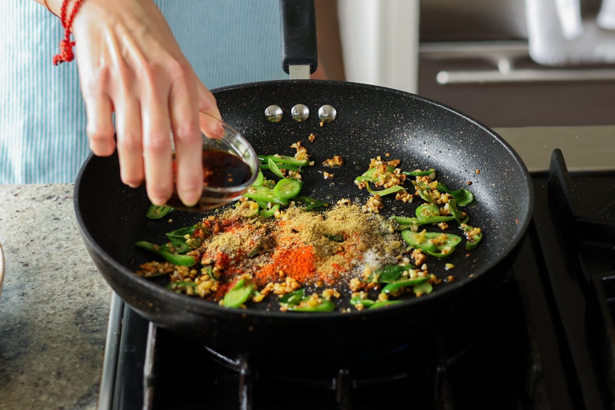 adding ground spices and sauces to the pan