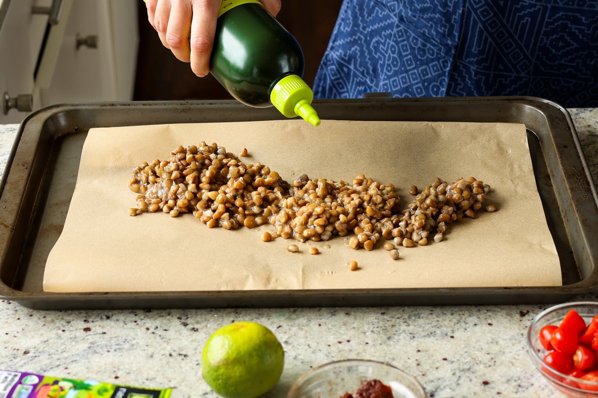 mixing lentils and oil on the baking sheet