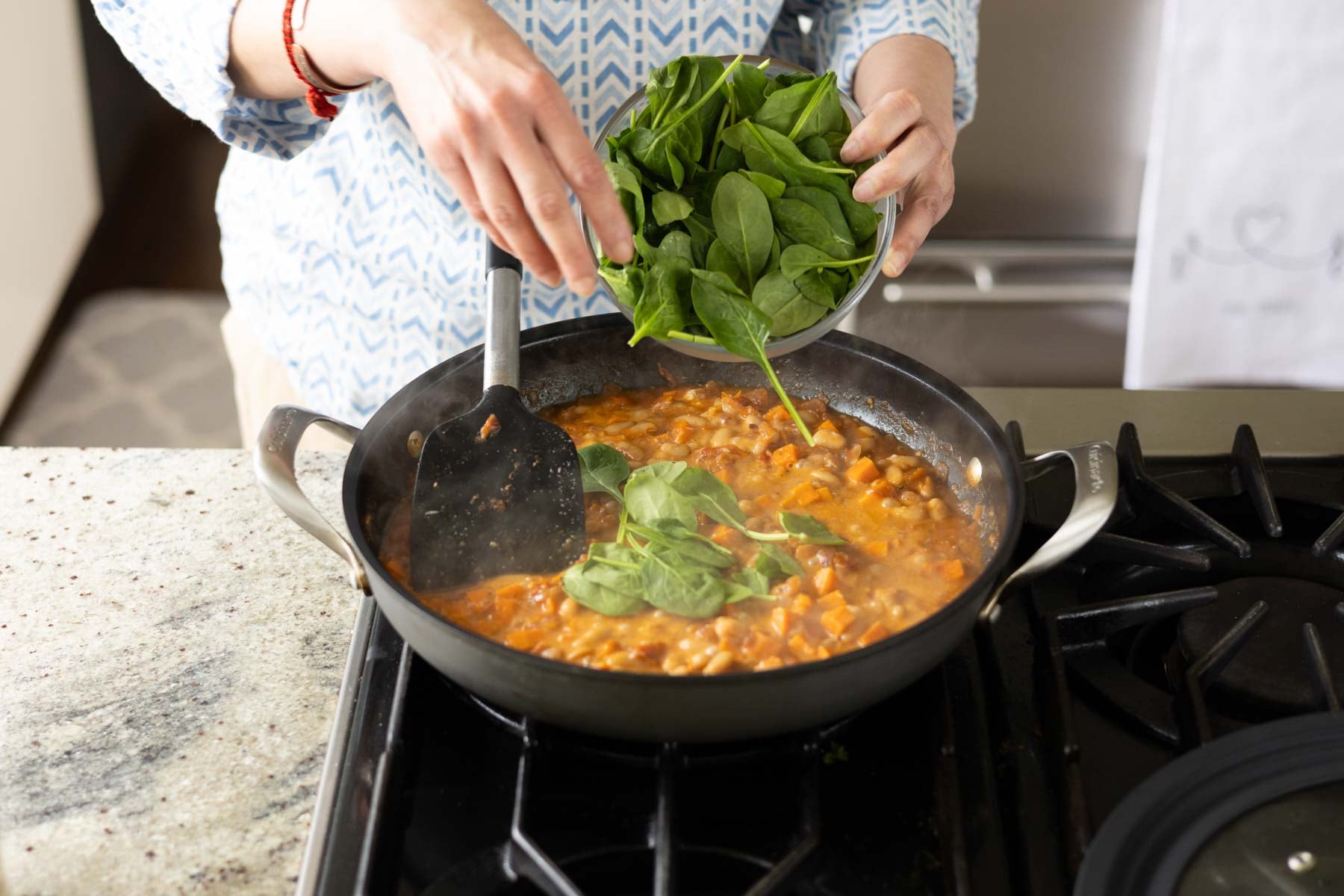 adding spinach to the pan