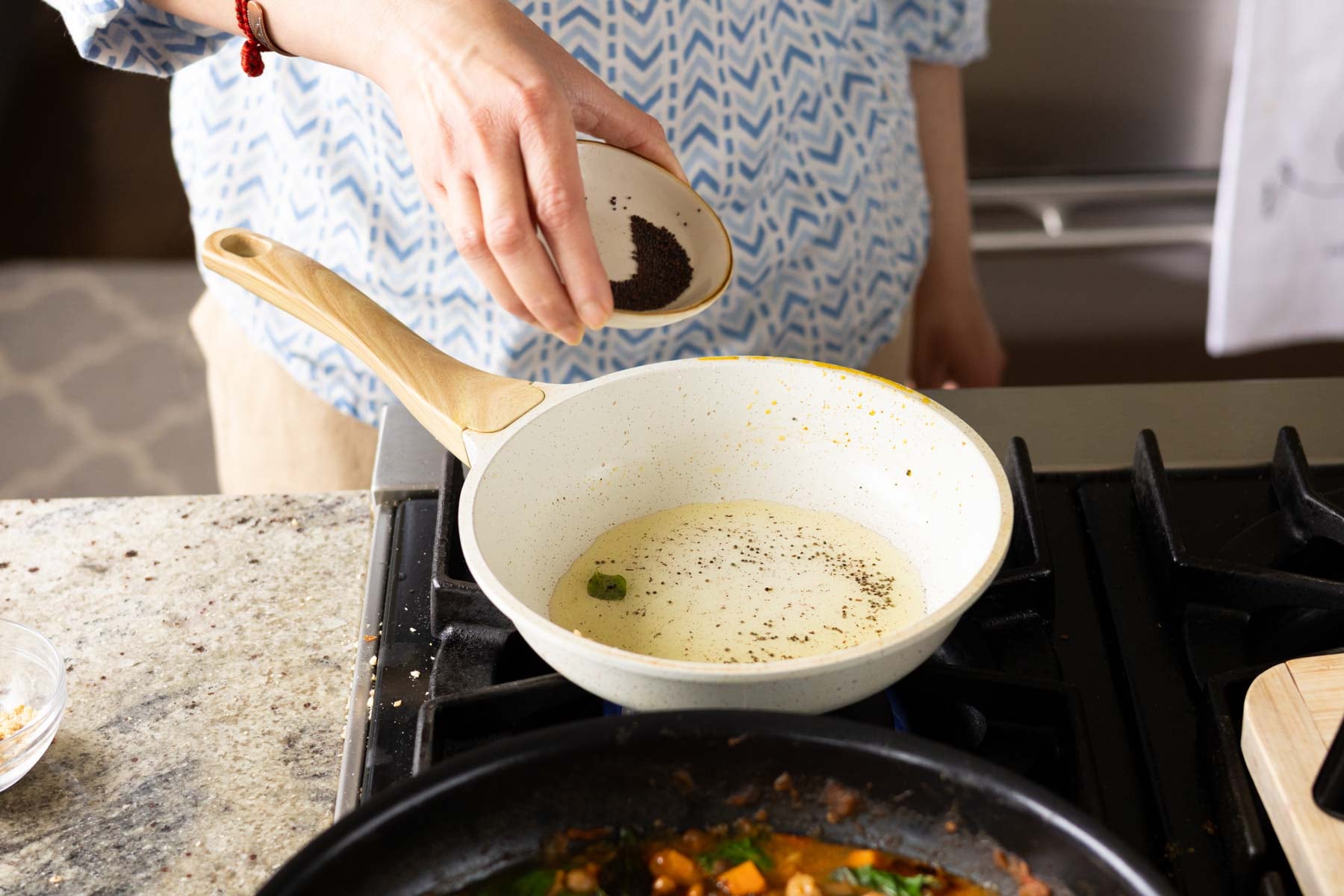 adding mustard seeds to the pan