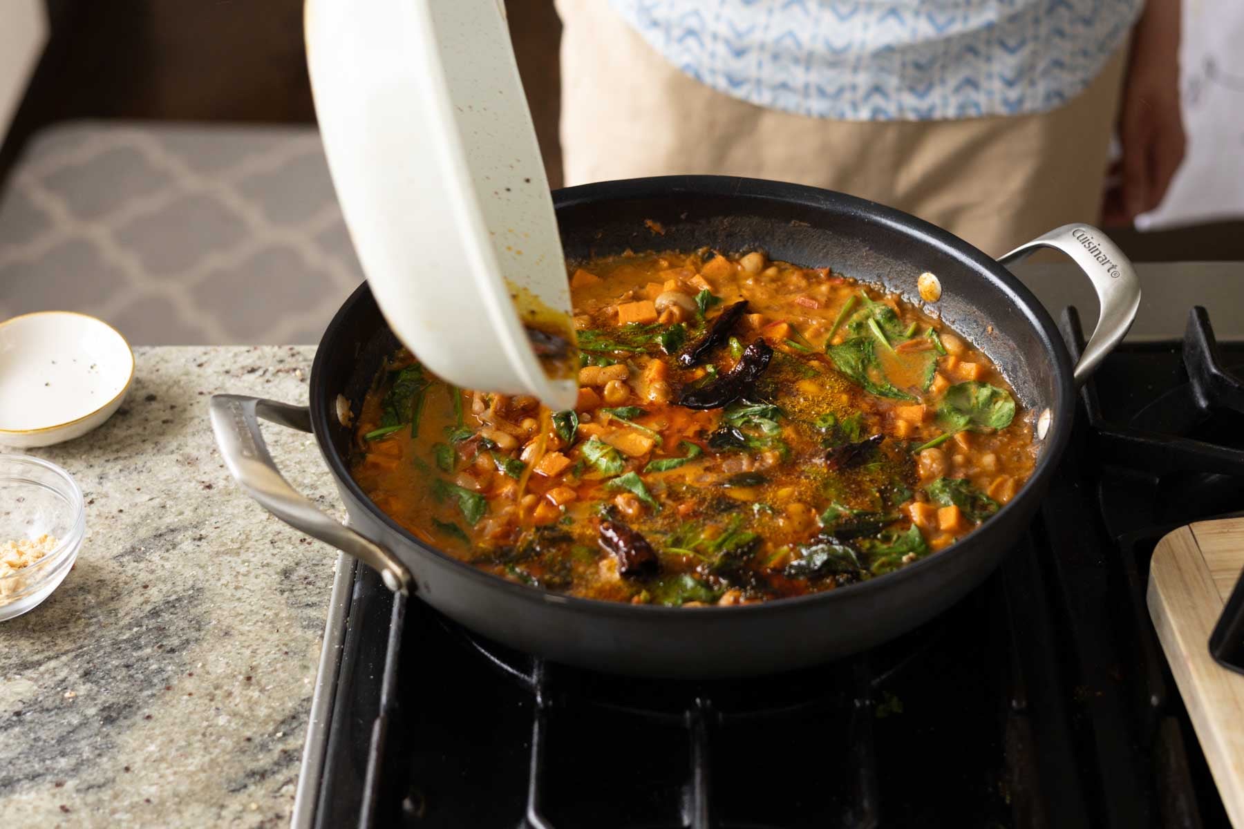 adding spiced oil to the Indian-inspired white bean stew