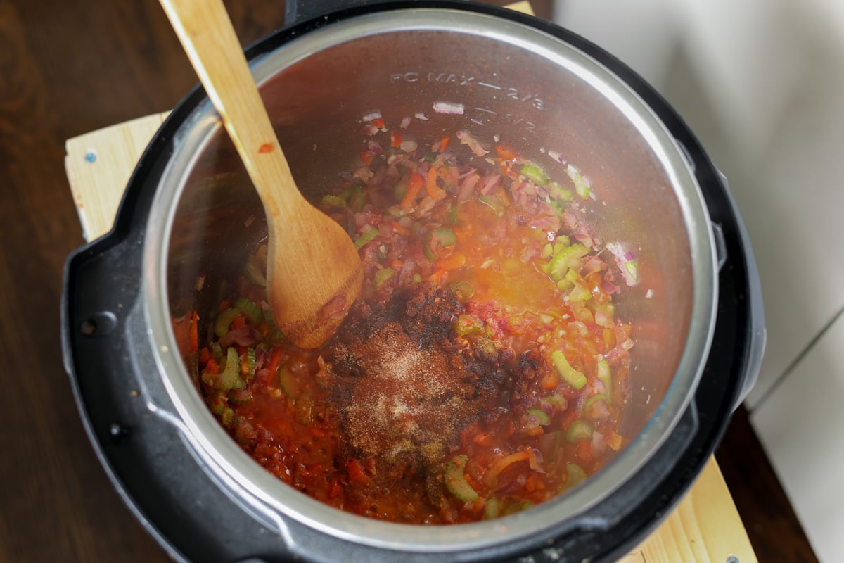 adding tomatoes and spices to the Instant Pot