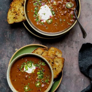 kidney bean chili in bowls with vegan sour cream and other toppings