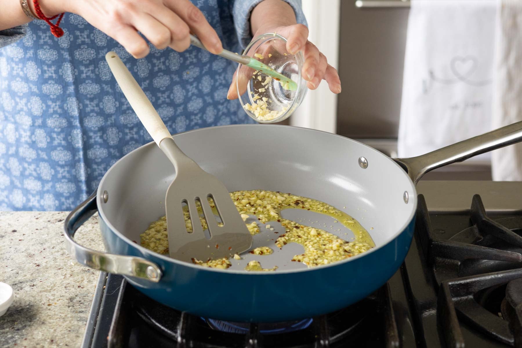 adding garlic and crushed pepper to the pan