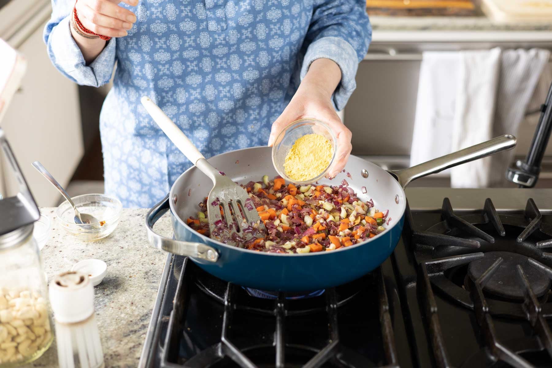 adding nutritional yeast to the cooked veggies