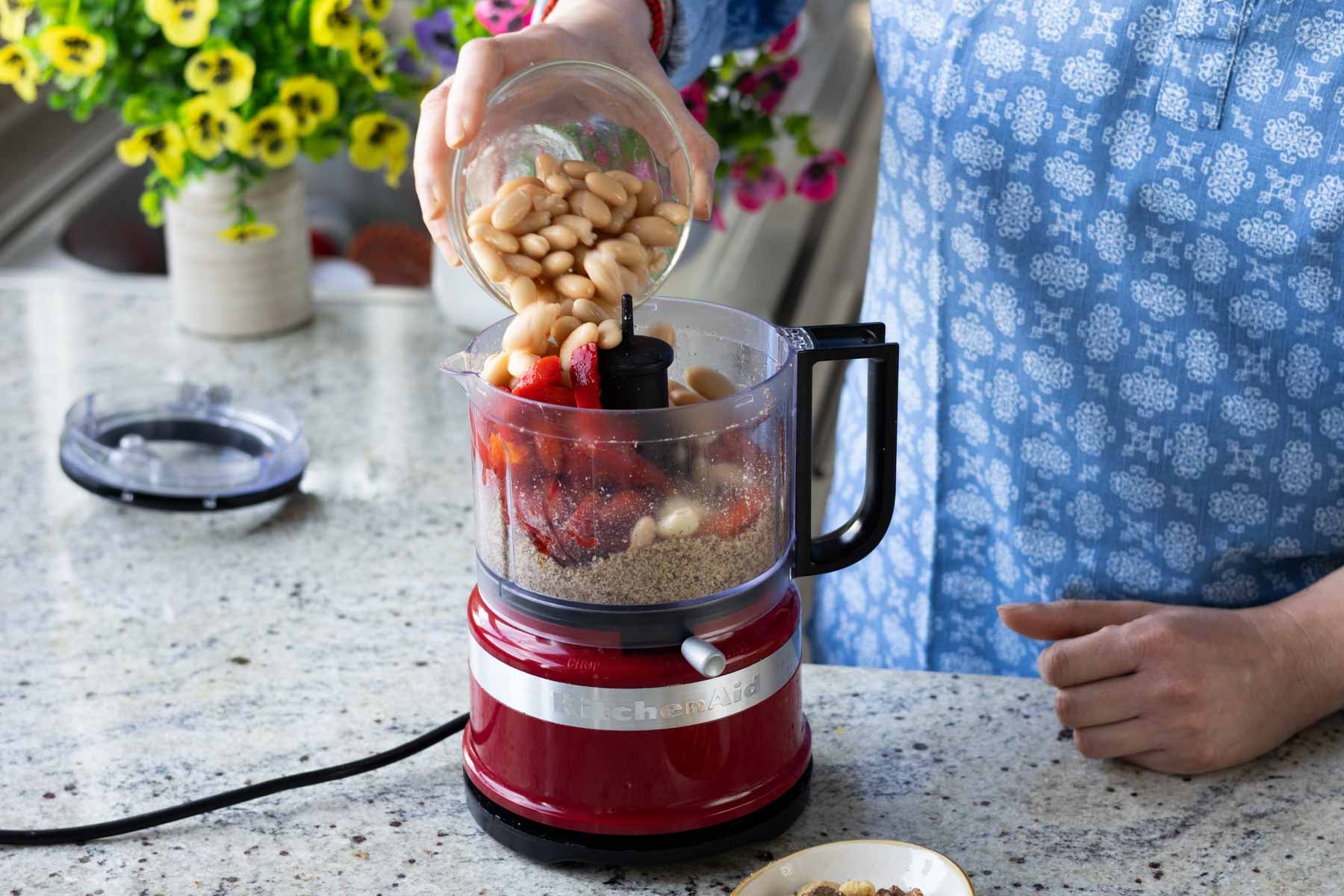 adding the rest of the Muhammara bean dip ingredients to the food processor