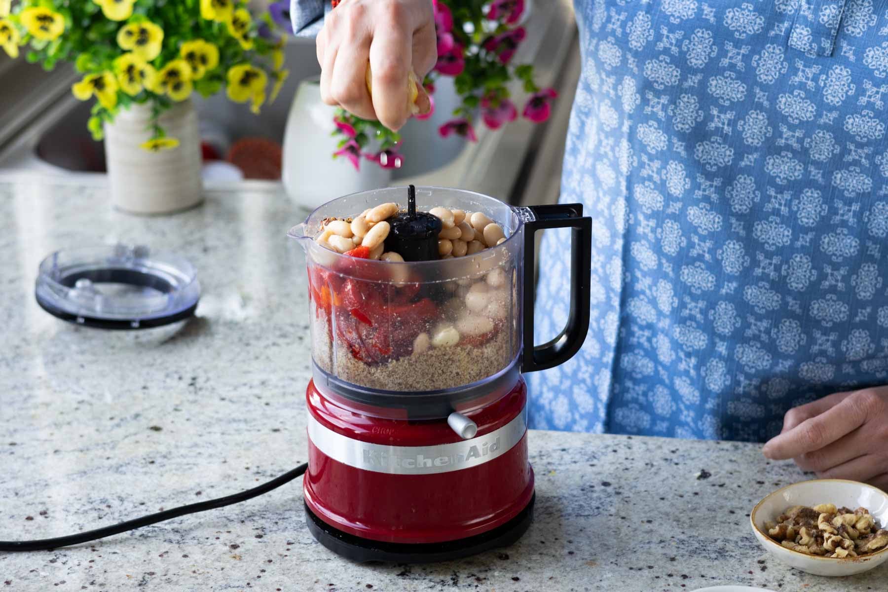 adding the rest of the Muhammara bean dip ingredients to the food processor