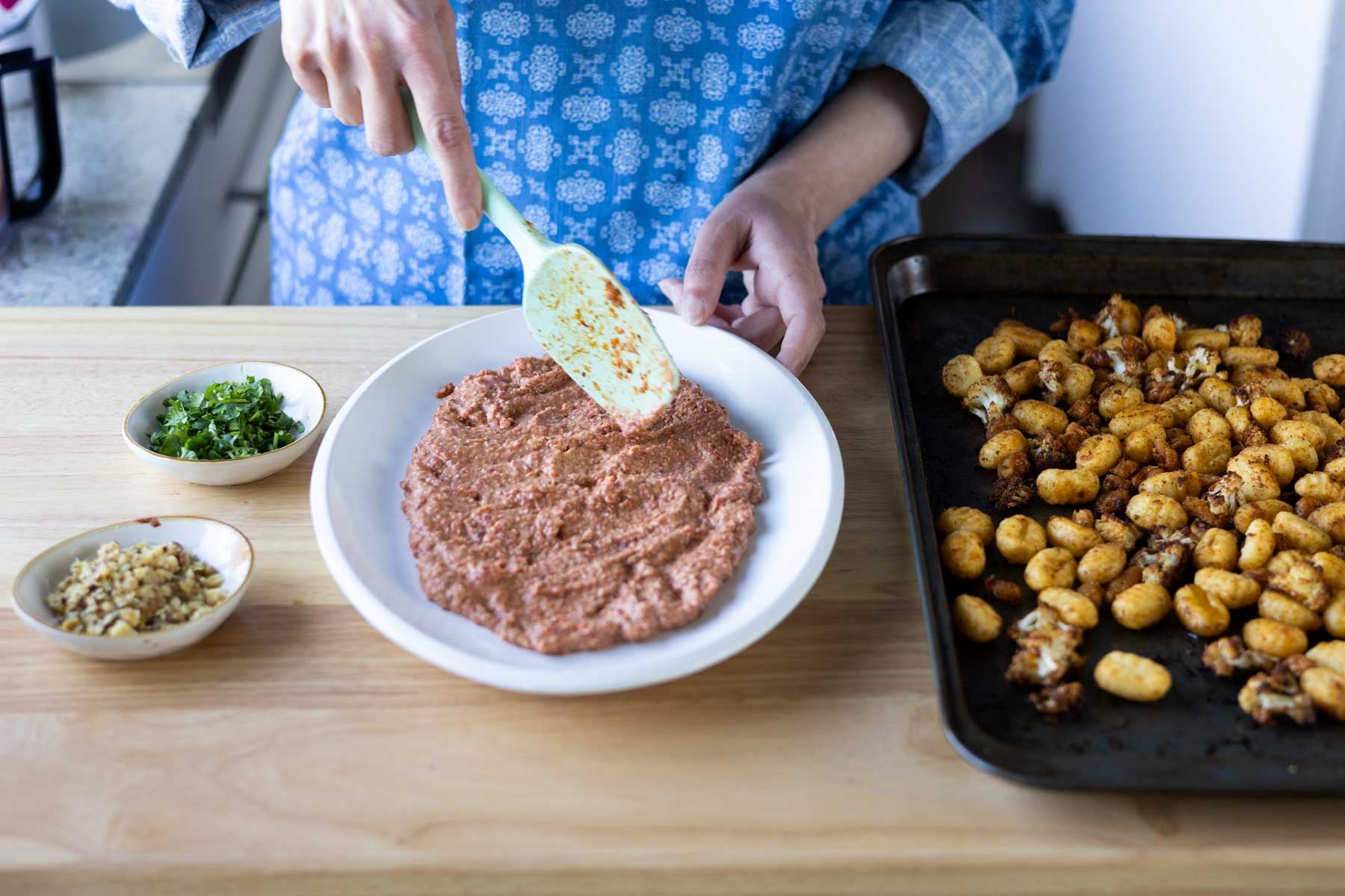 spreading the Muhammara bean dip on a plate