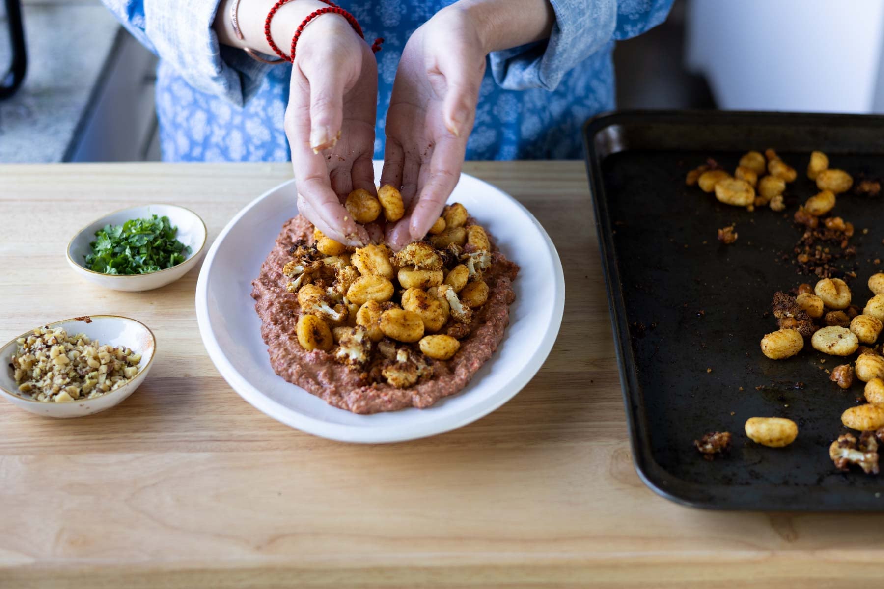adding the gnocchi, beans, and cauliflower to the plate
